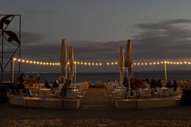 Ospătar care explică meniul unui cuplu de turiști străini la o masă de restaurant cu decor tradițional