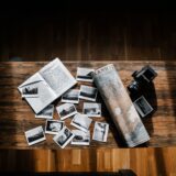 Hartă deschisă pe o masă de lemn, alături de un carnet de notițe, un pix și o cană de cafea pentru planificarea vacanței